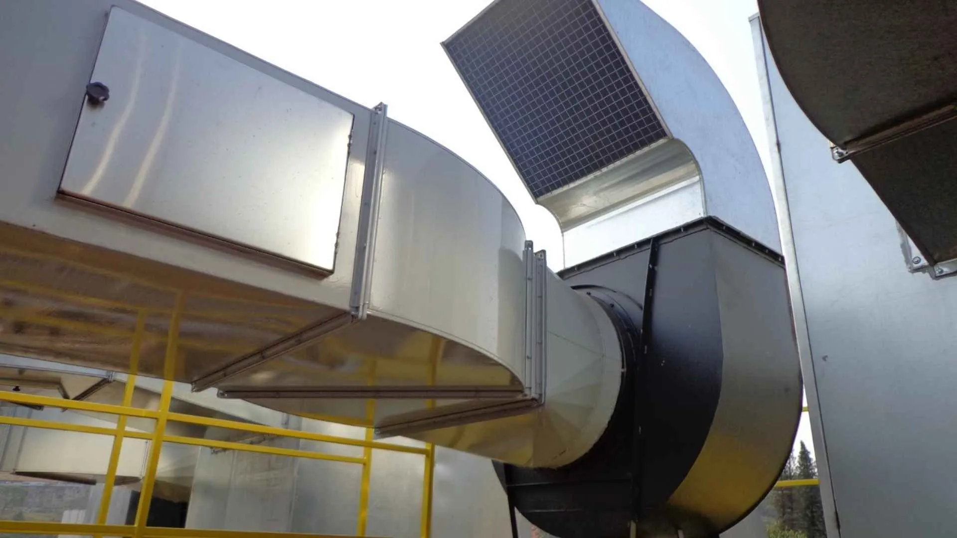 Sistema de exaustão industrial instalado em galpão com dutos metálicos